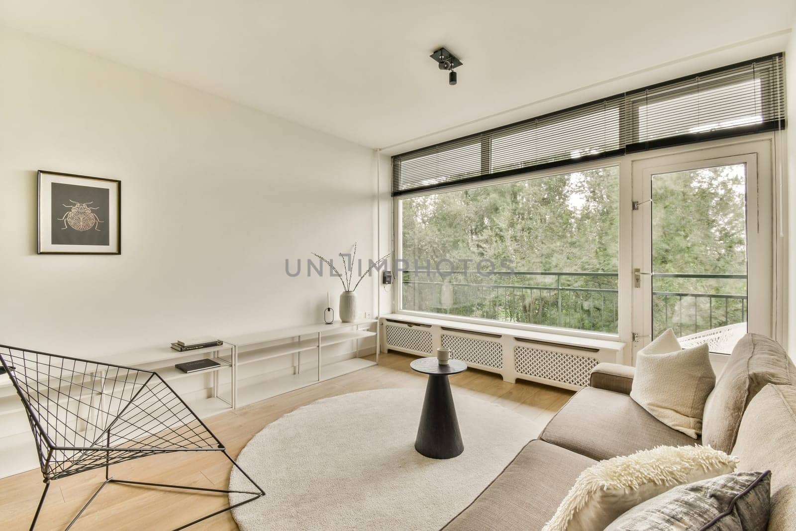 A contemporary living room featuring sleek furniture, large windows allowing natural light, and a minimalistic design. Ideal for cozy gatherings or relaxation.