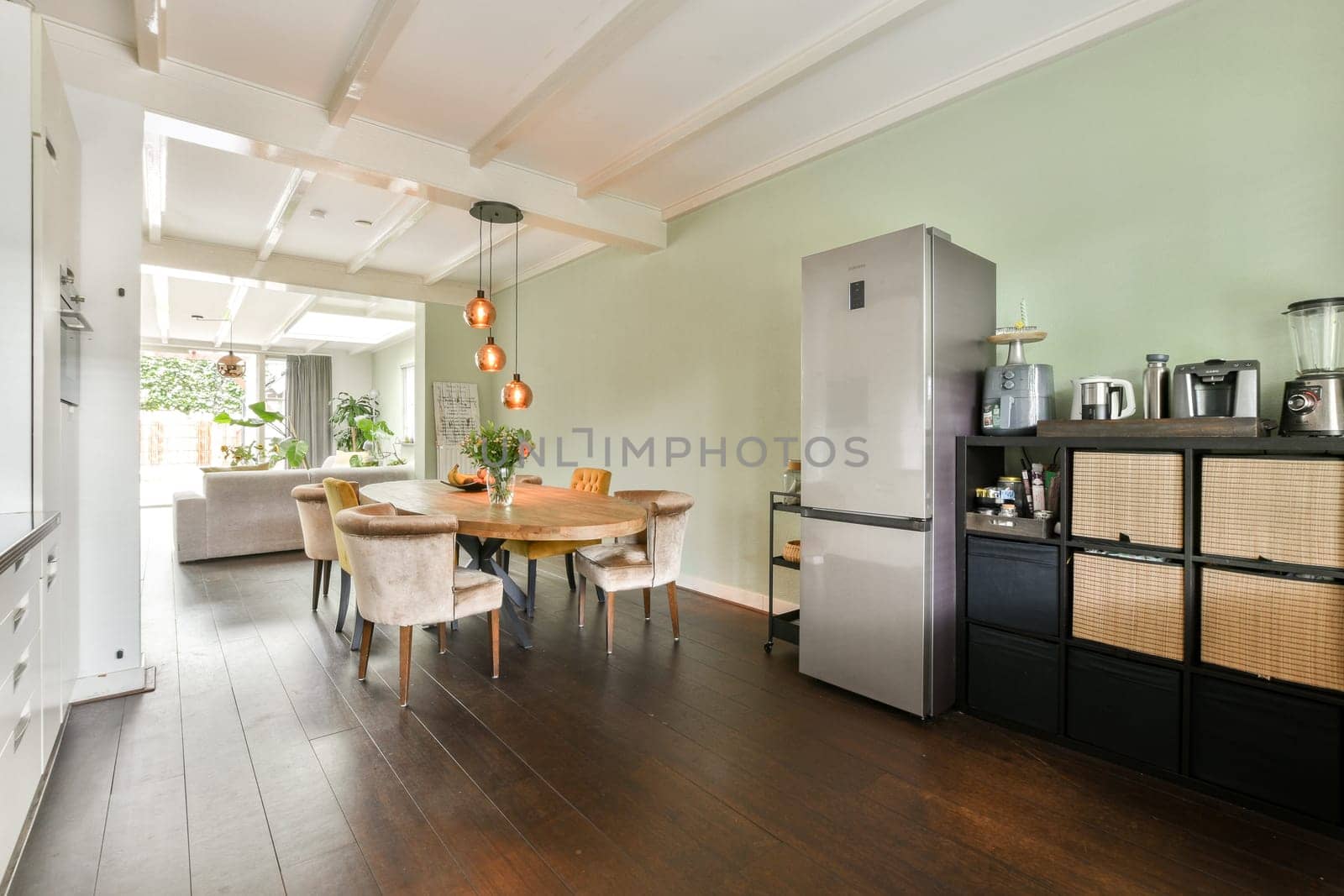 A stylish kitchen featuring a sophisticated dining area, sleek refrigerator, and warm lighting, perfect for entertaining and everyday meals.