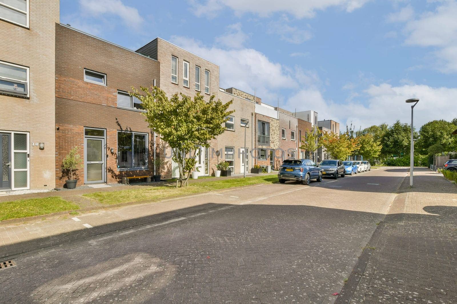 A serene scene depicting a modern residential street lined with contemporary houses and lush greenery, creating an inviting atmosphere.