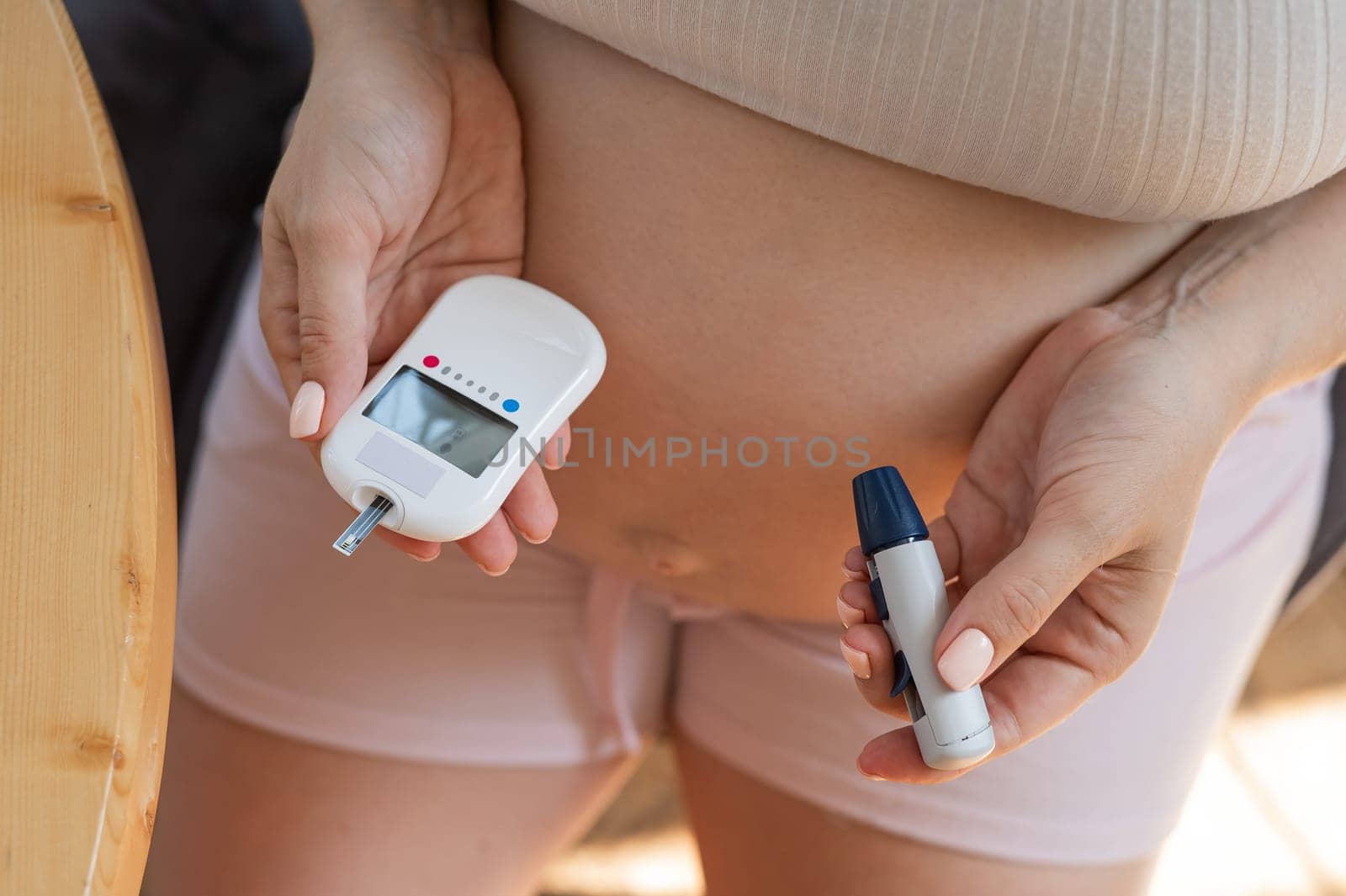 Pregnant woman doing home blood sugar test. Gestational diabetes
