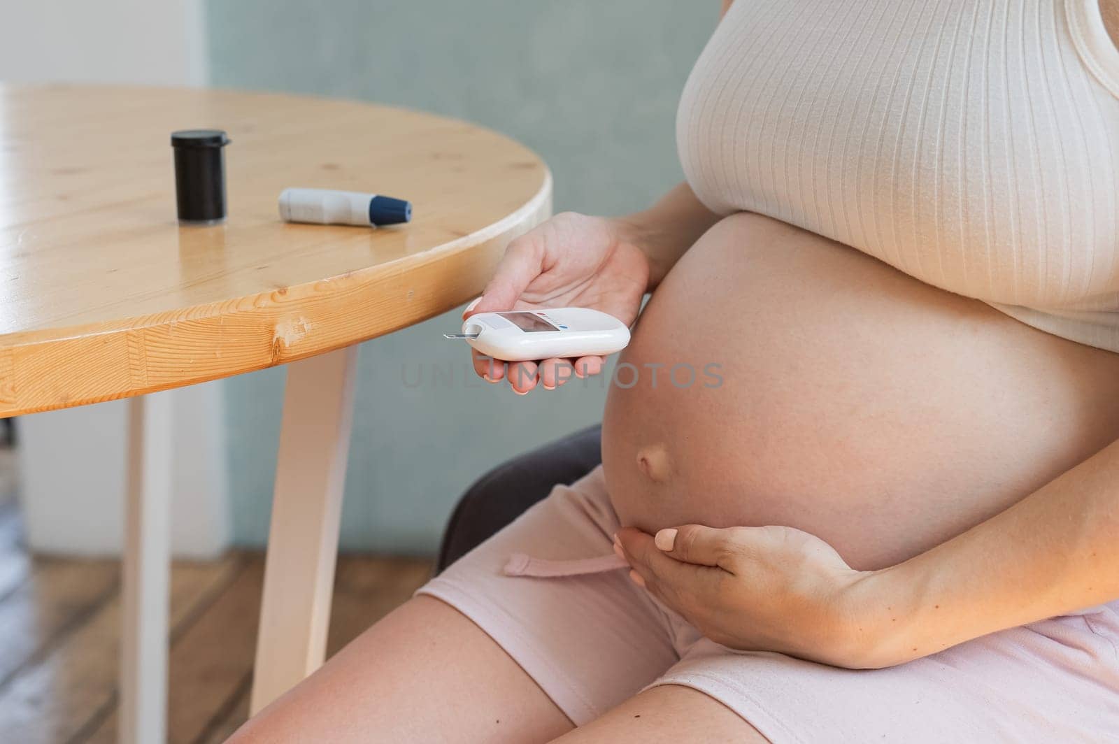 Pregnant woman doing home blood sugar test. Gestational diabetes