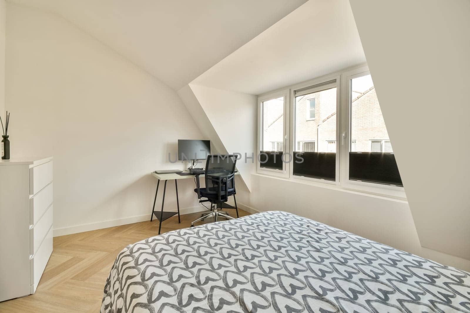 A well-designed bedroom featuring minimalist furniture, large windows, and a blend of natural light with contemporary decor, creating a welcoming atmosphere.