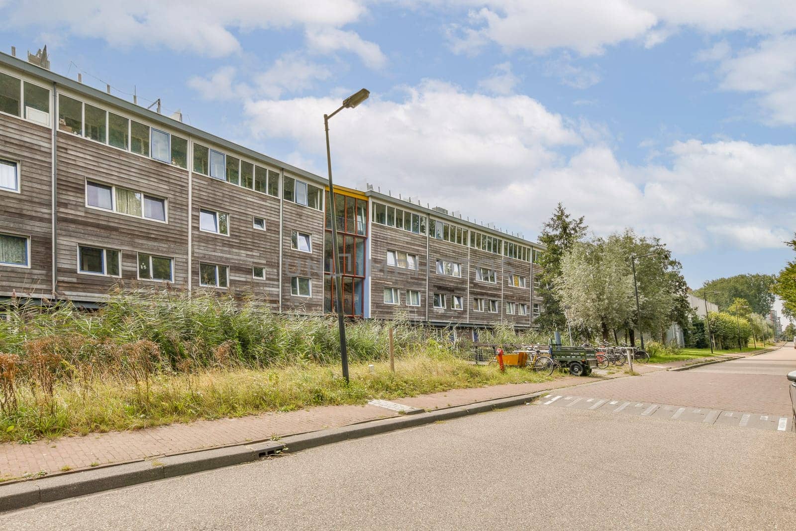 A contemporary residential structure surrounded by lush greenery and a clear blue sky, showcasing the beauty of urban living harmonized with nature.