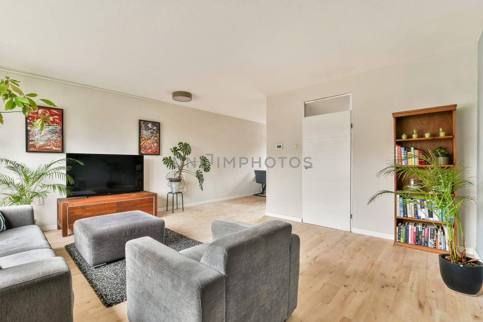 A stylish and contemporary living room showcasing a neutral color palette, comfortable seating, and decorative plants for a warm atmosphere.