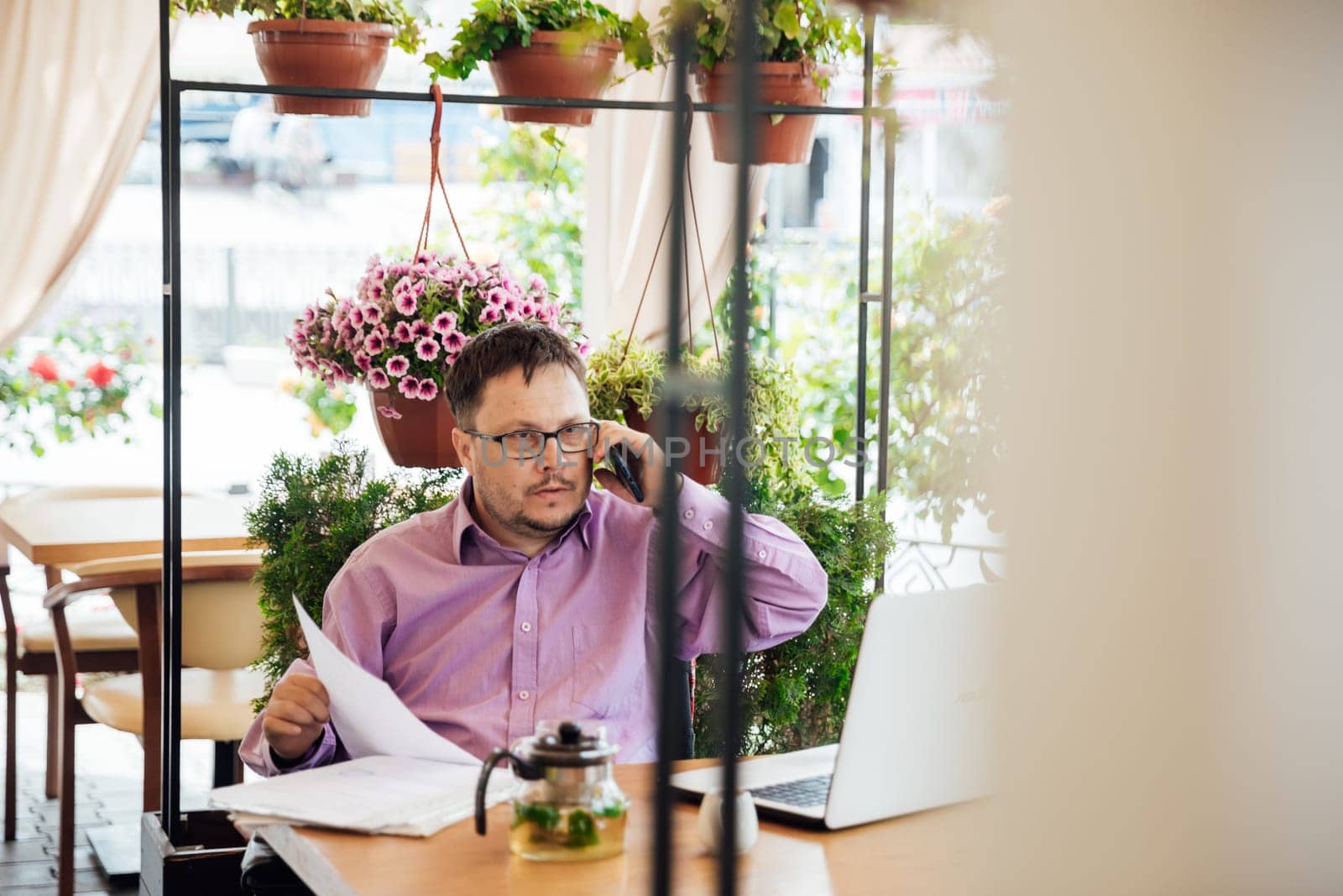 Man working on laptop online at table with food in restaurant
