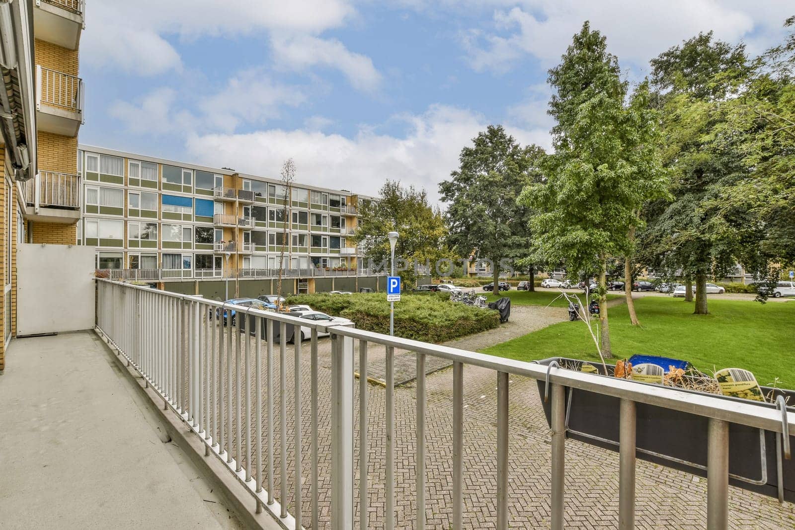 A modern residential building overlooks a well-maintained green park area, showcasing urban architecture and nature's beauty in harmony.