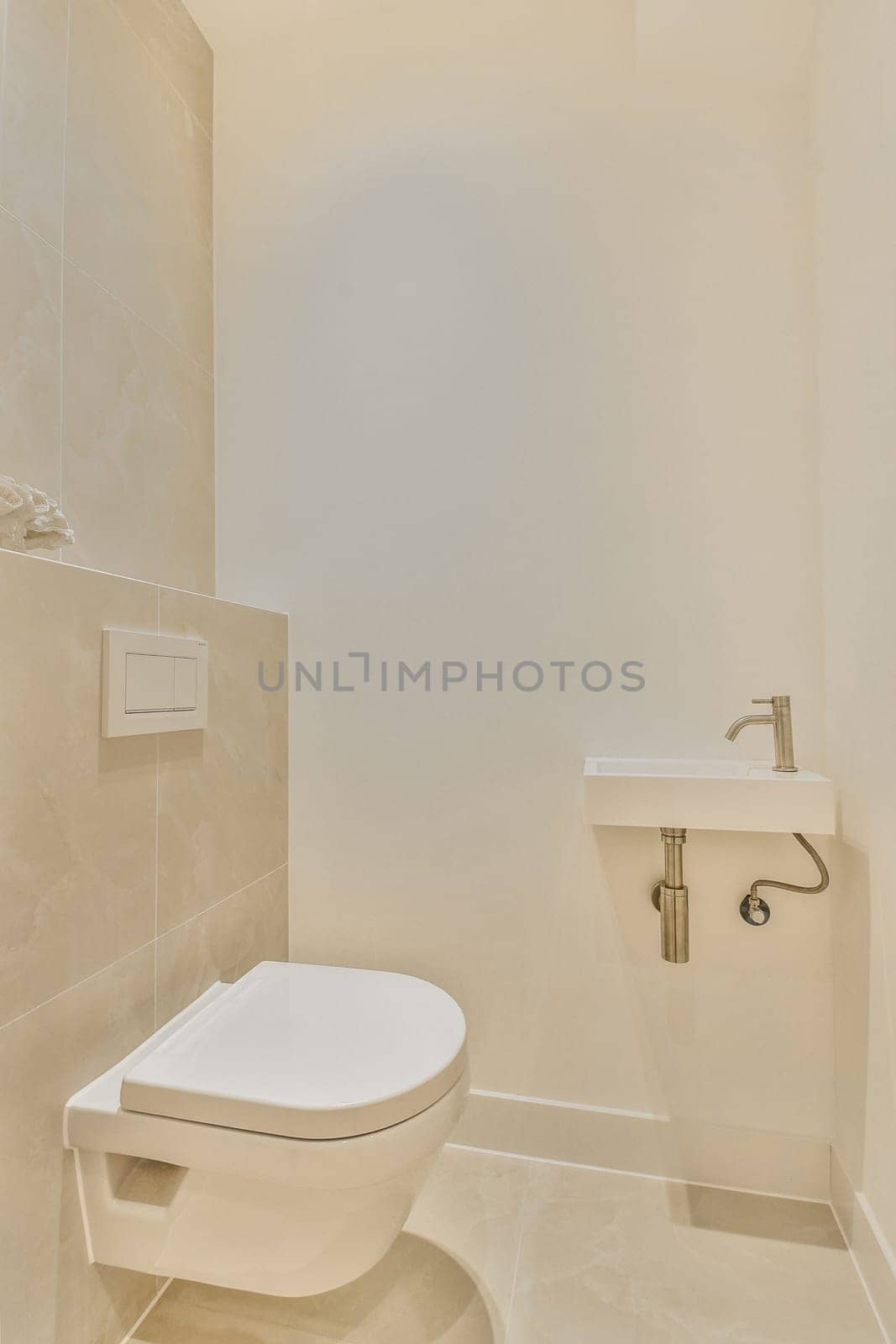 Elegant minimalist bathroom featuring a modern toilet and sleek fixtures against light tile walls, creating a clean and spacious ambiance.