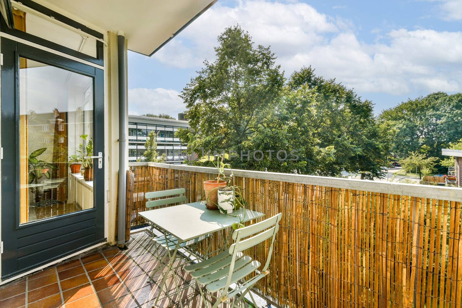 A bright and inviting balcony adorned with lush greenery and a cozy seating arrangement, perfect for relaxing outdoors in a serene environment.