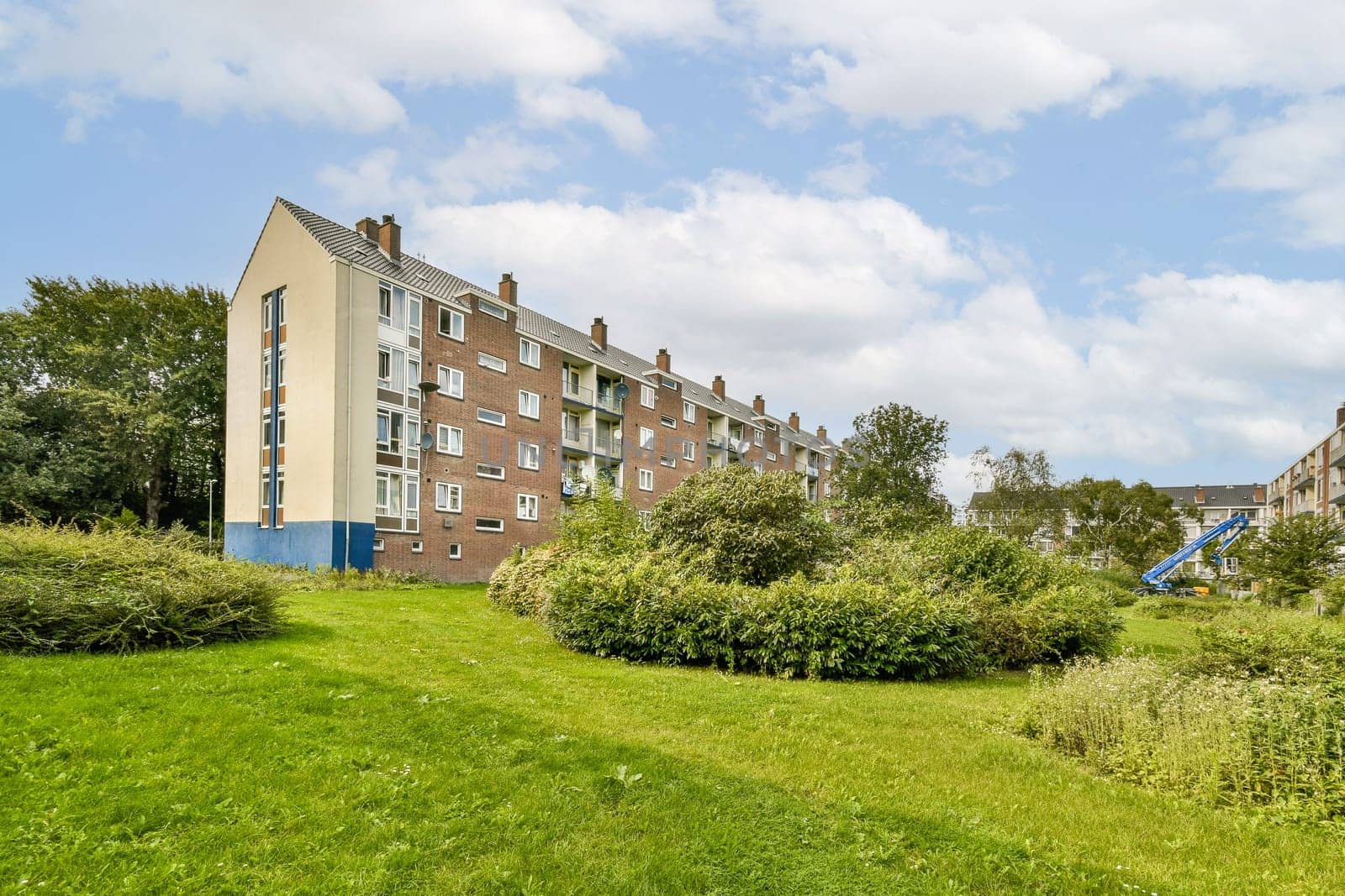A contemporary residential complex nestled among lush greenery, showcasing urban living in harmony with nature, ideal for community and family life.