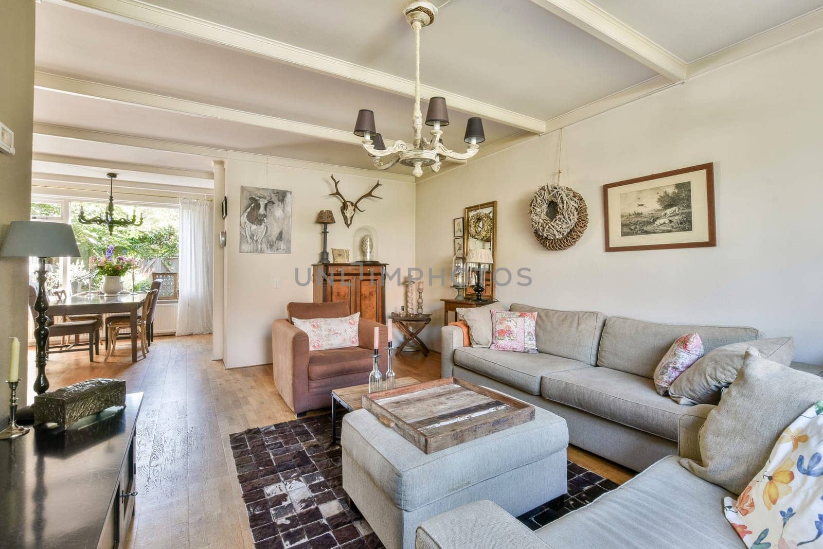 A beautifully designed living room featuring a comfortable sofa, stylish decor, and a dining area that welcomes natural light and warmth into the space.