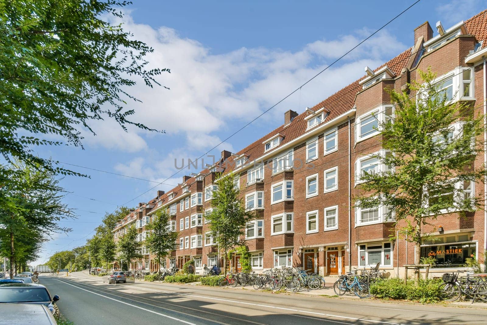 A picturesque streetscape featuring charming brick buildings, lush trees, and a peaceful road lined with greenery, creating a serene urban ambiance.