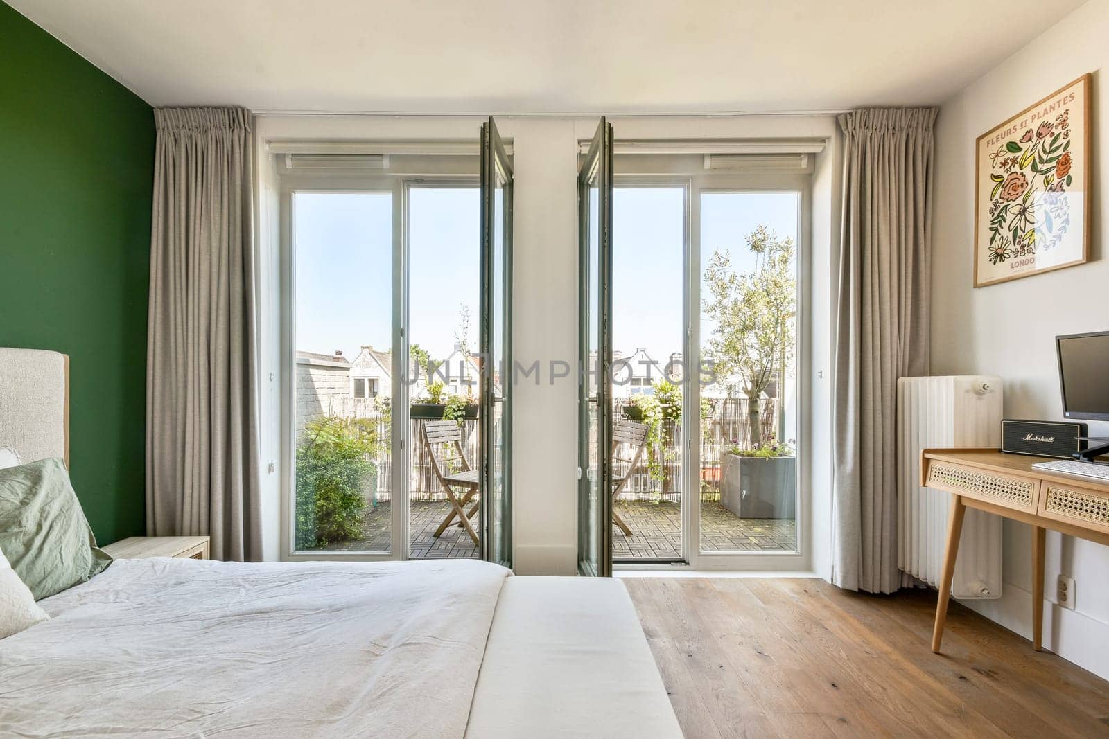 A contemporary bedroom featuring large windows that offer a view of the outdoor garden, paired with elegant furnishings and a calming color palette.
