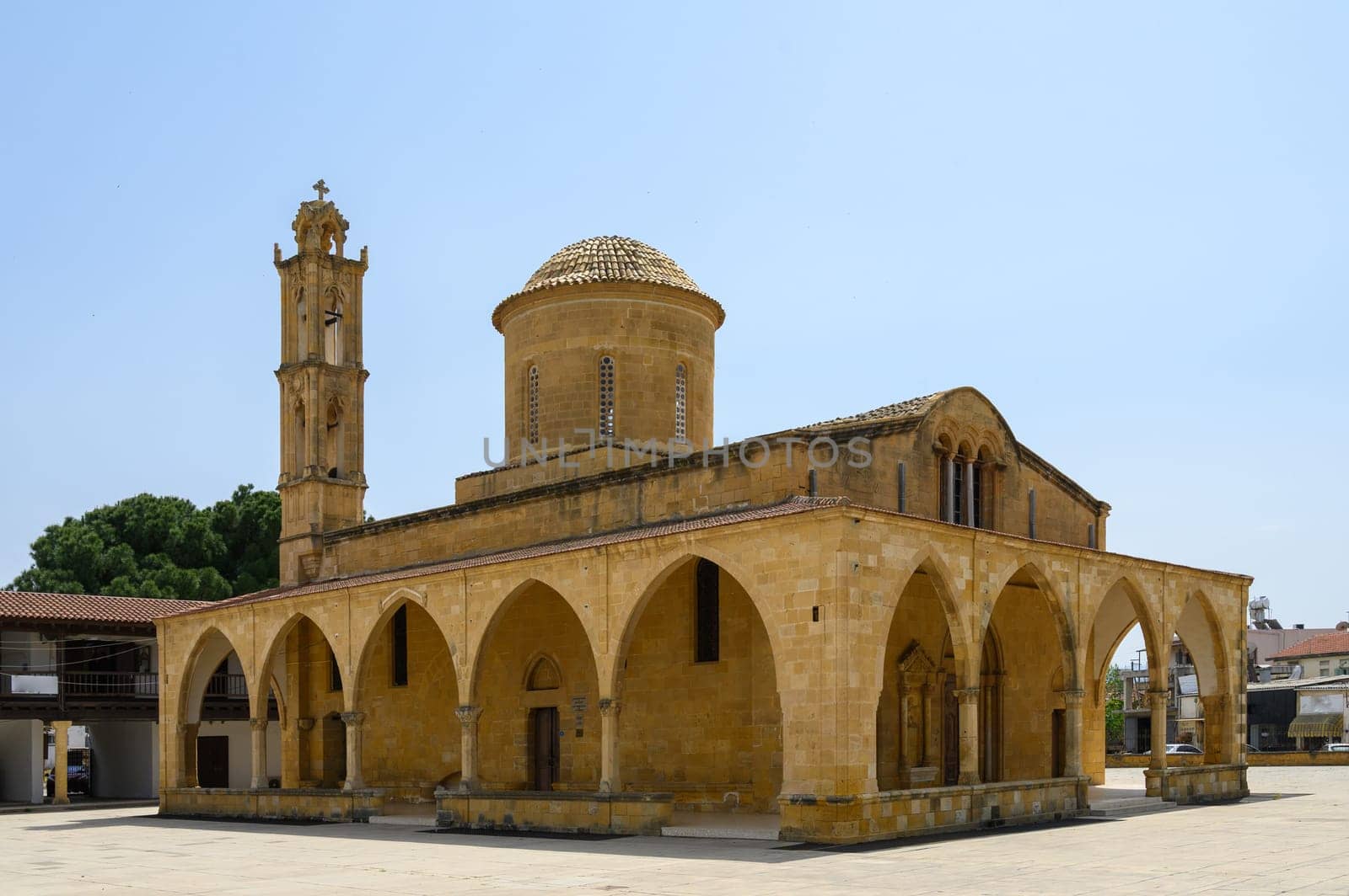 Majestic Selimiye Mosque stands proudly with its intricate arches and dome, surrounded by vibrant greenery on a sunny day in Nicosia, Cyprus. Visitors marvel at its beauty.