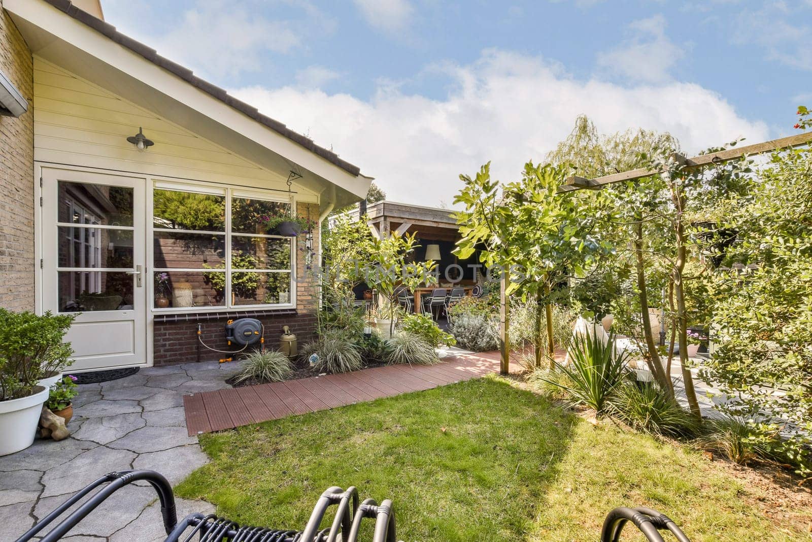 A beautifully designed garden featuring lush greenery, pathways, and cozy seating arrangements, perfect for outdoor relaxation and enjoyment.