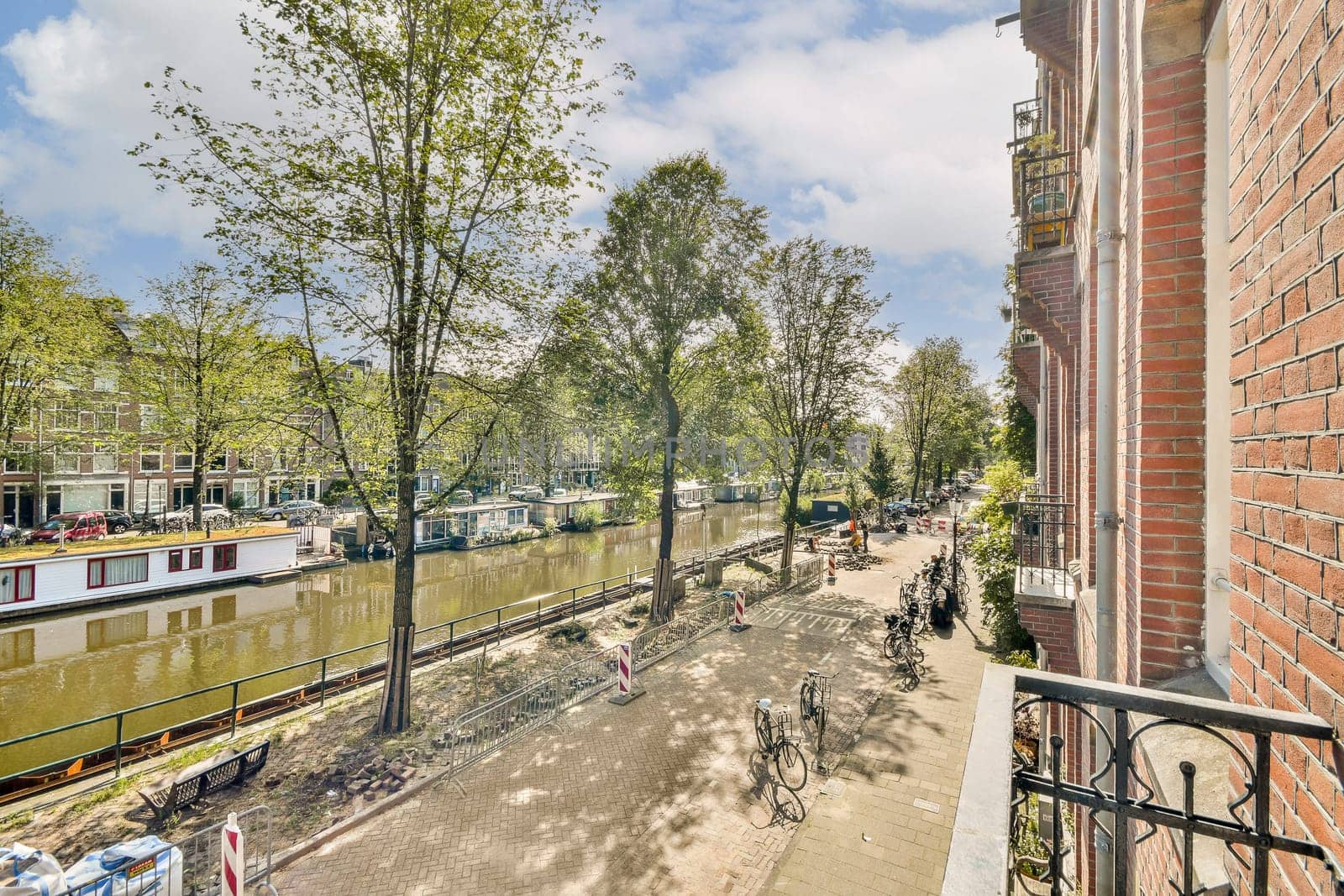 A picturesque view along a riverbank featuring vibrant greenery and charming bicycles parked beside the water, creating a serene urban landscape.