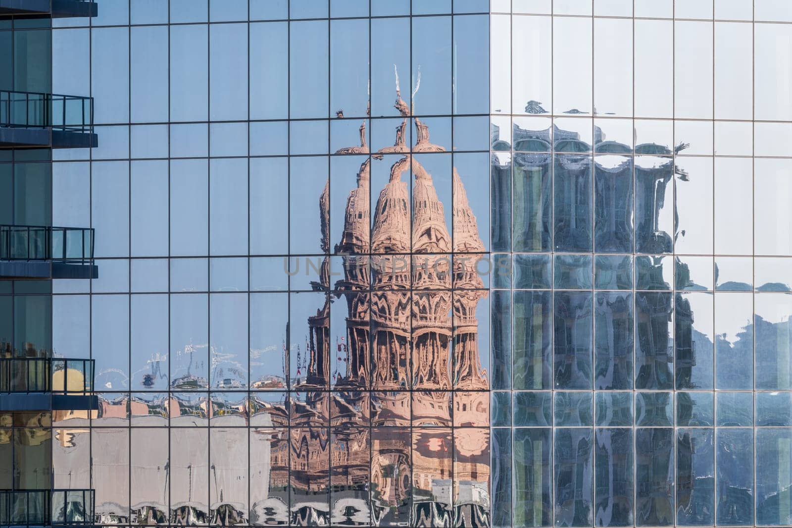 Reflection of the Texas State Capitol dome in the multiple glass windows of modern skyscraper in Austin