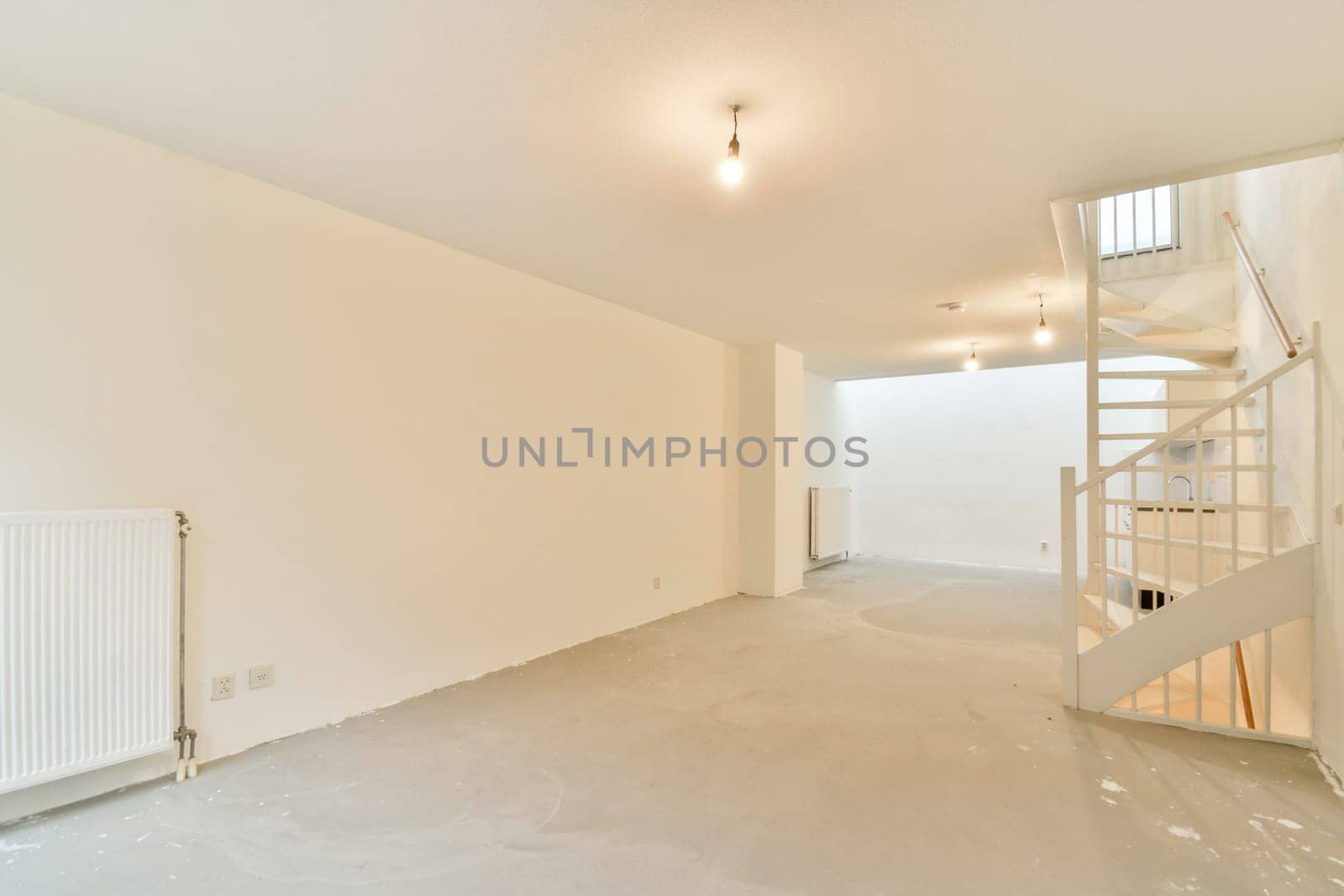 A spacious, unfinished modern interior featuring clean lines, neutral colors, and ample natural light. It includes a spiral staircase and minimalistic design elements.