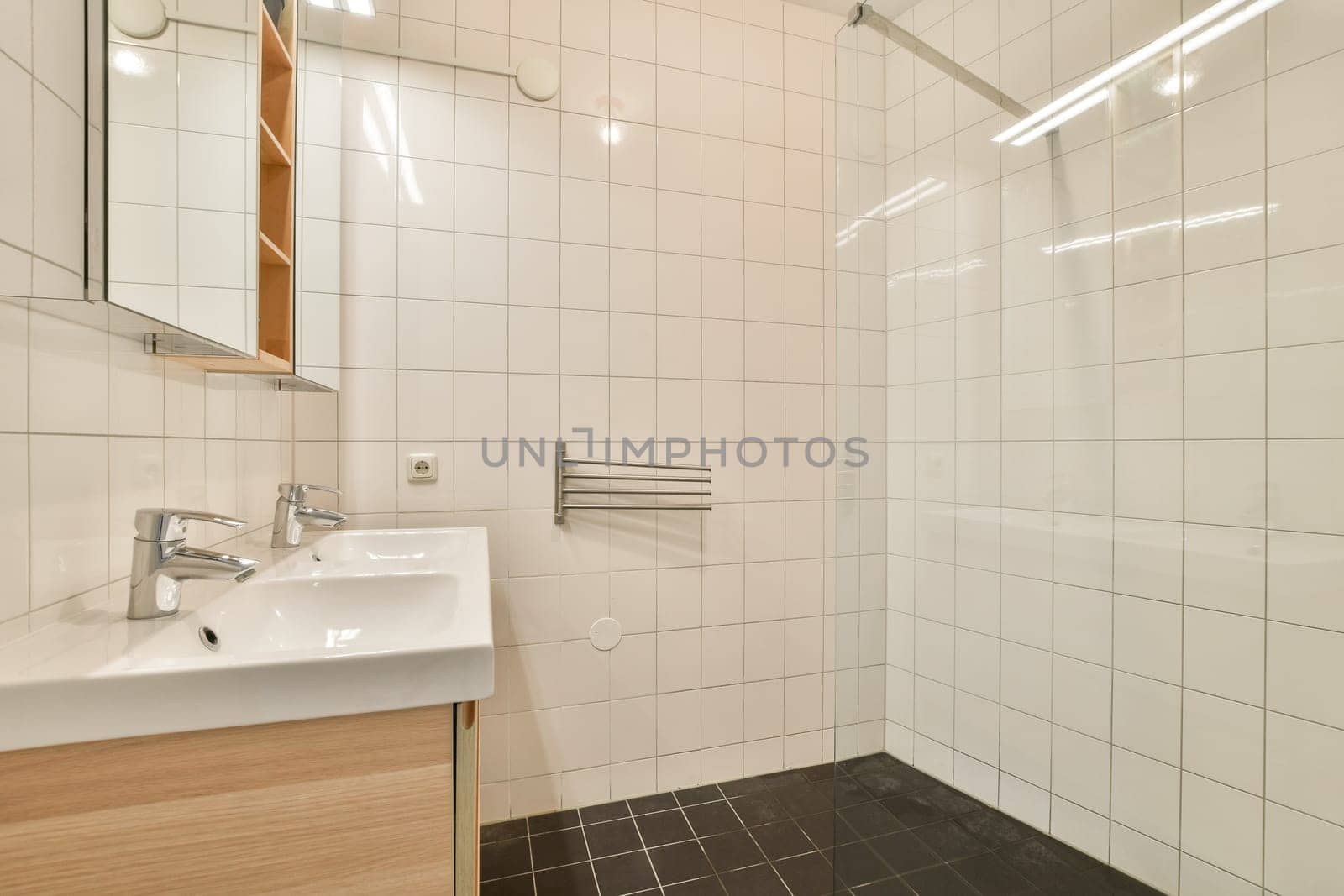 A sleek and stylish modern bathroom featuring a combined shower area and dual sinks. The design emphasizes cleanliness with neutral tones and contemporary fixtures.
