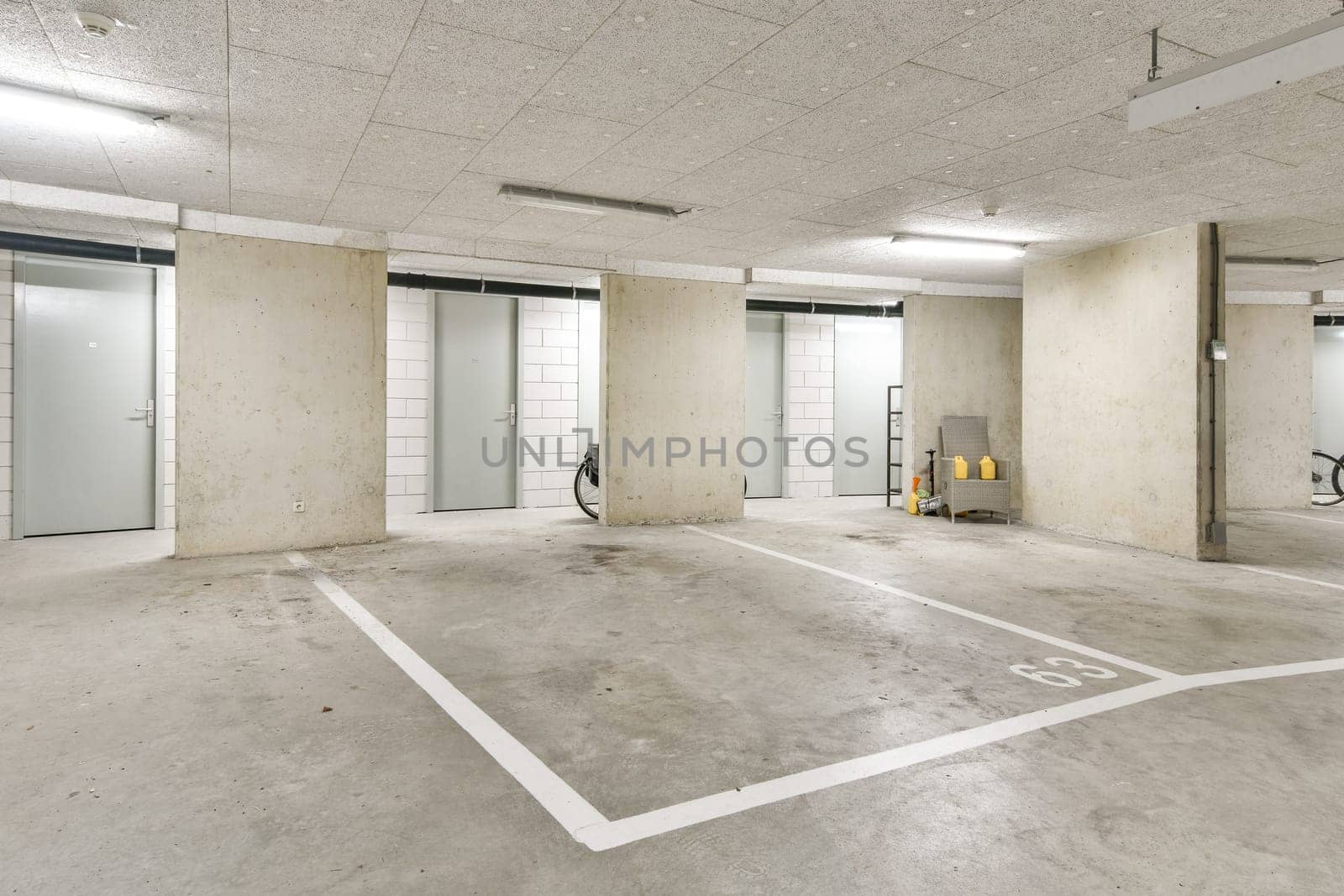 An organized and clean interior of a modern parking garage featuring numbered spaces and minimalistic walls.
