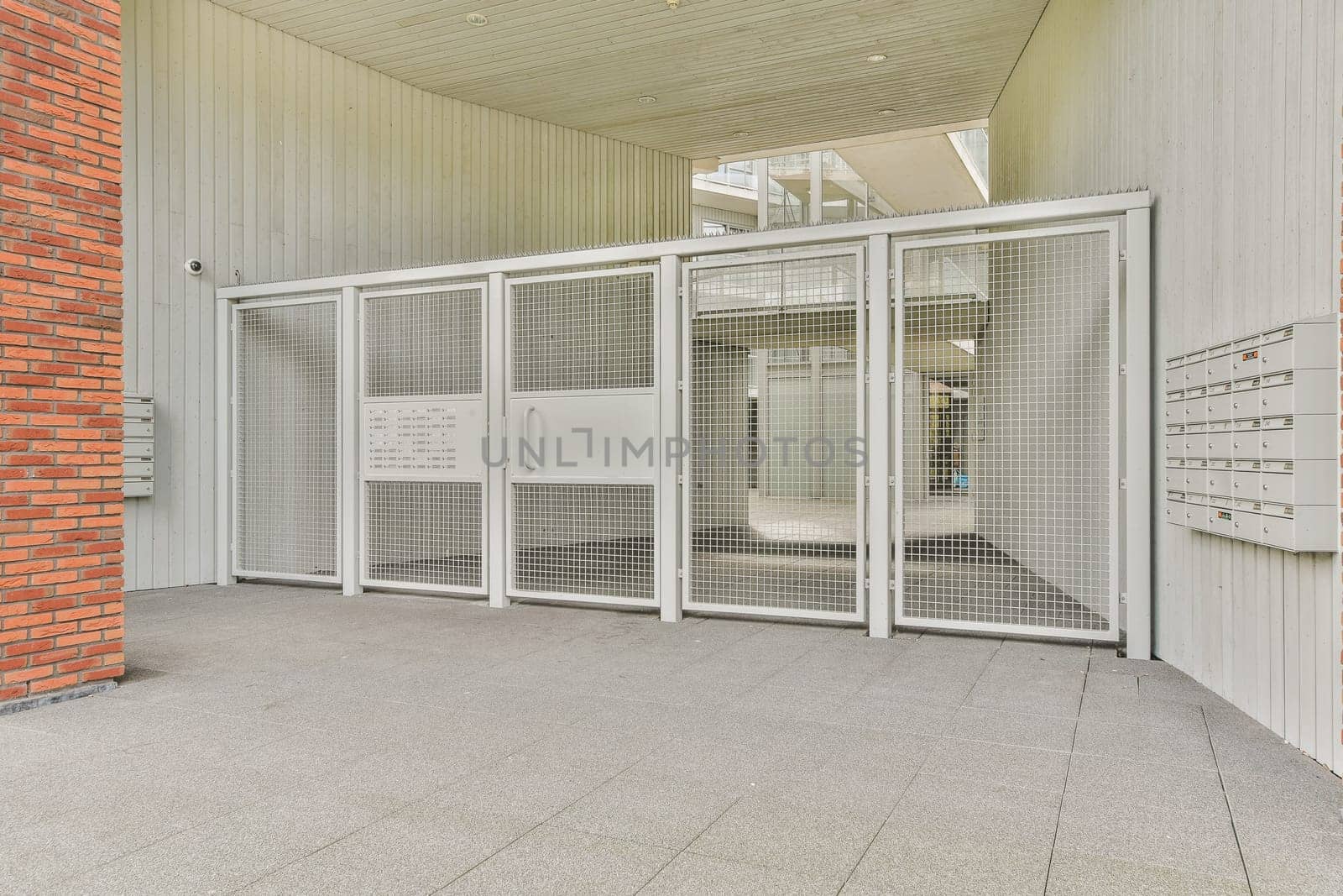 A contemporary entrance showcasing a mesh door design, featuring sleek lines and minimalist aesthetics, complemented by an industrial ambiance.