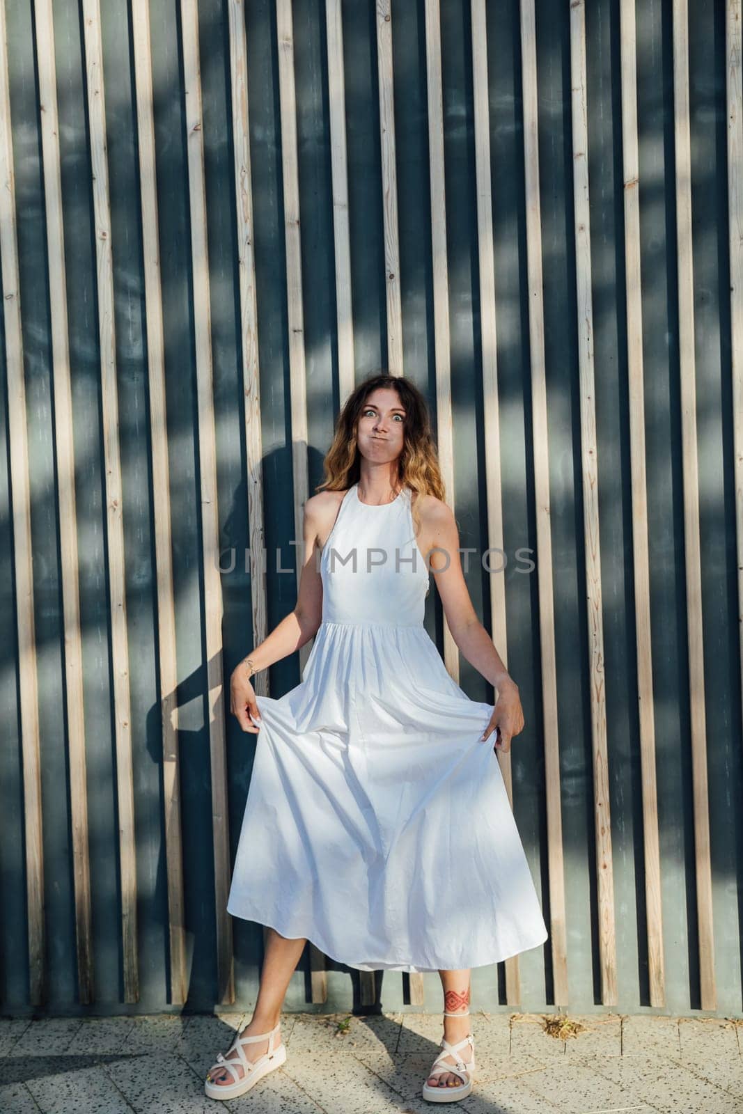 Portrait of a woman smiling in a light summer dress in the park on a walk