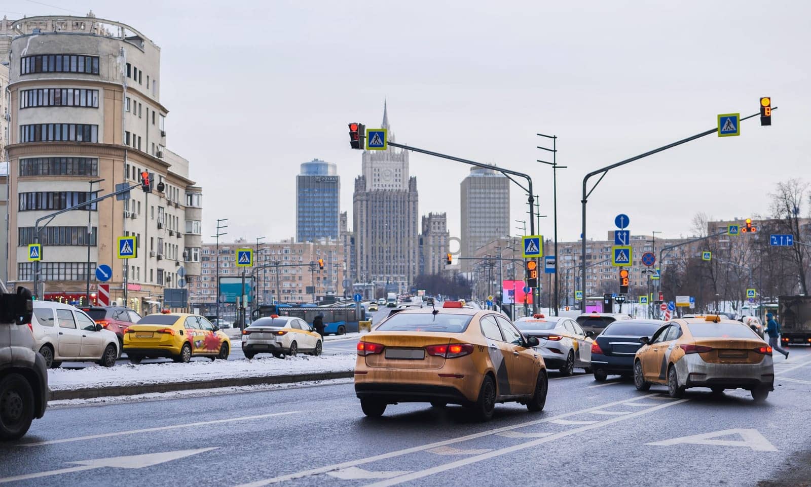 Yellow taxis driving on a winter day in Moscow with the Ministry of Foreign Affairs of Russia building in the background