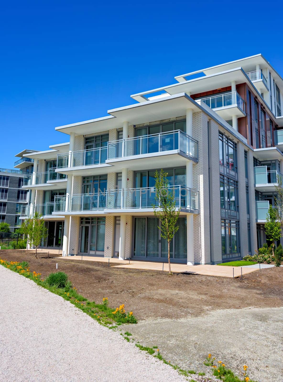 Gravel pathway along the new residential buildings on blue sky background