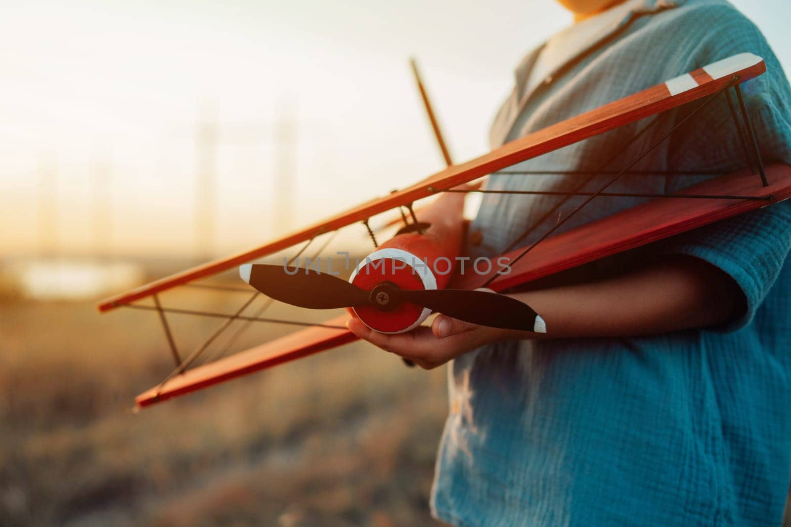 5 years old preschool child boy plays with craft wooden retro styled airplane toy, discovering future profession interest, dreamer kid flying, traveling. High quality photo
