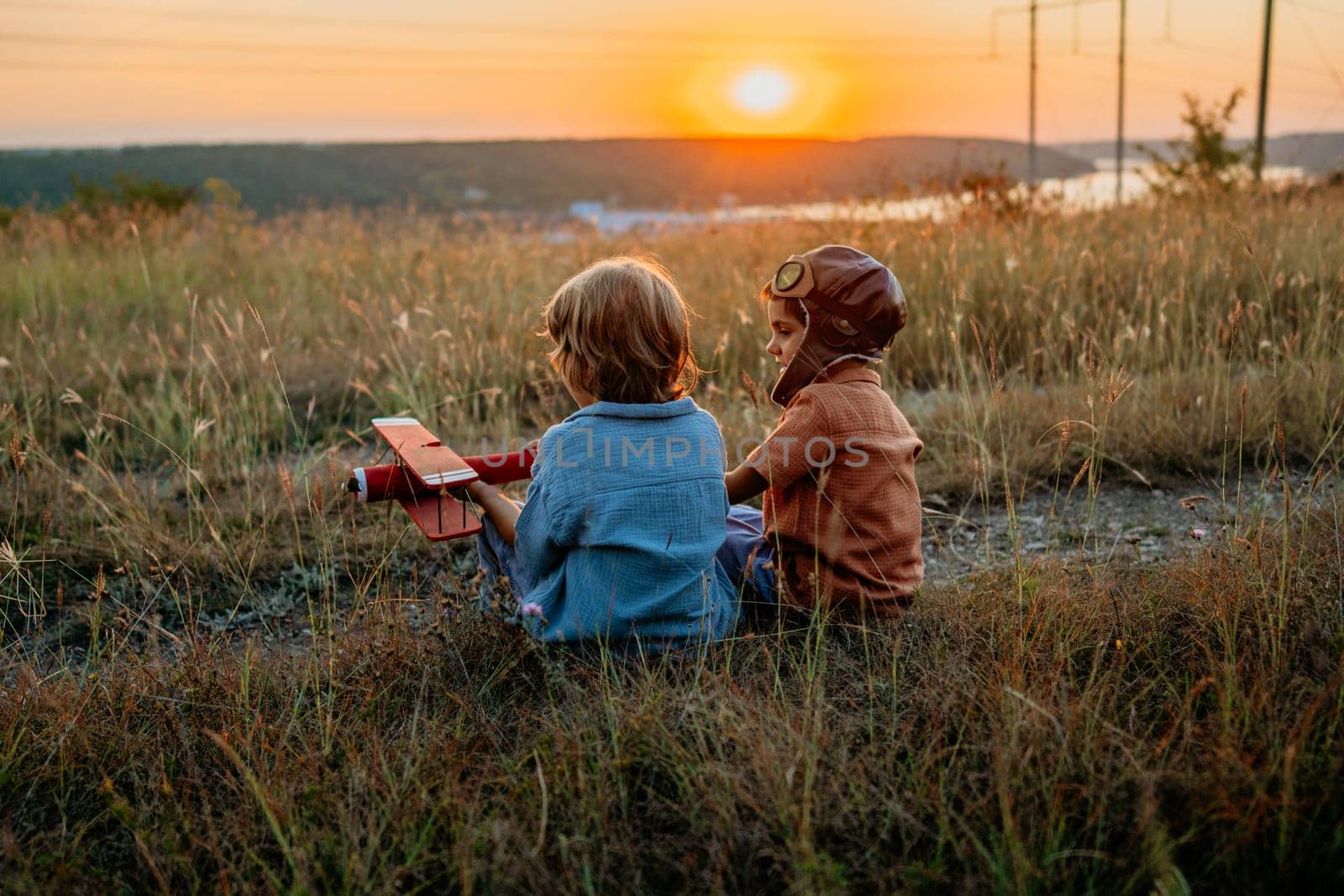 Smiling interested friends brothers, cute boys plays, talks about aviation with handmade wooden vintage plane toy, discovering future pilot profession interests, dreamers kids flying, traveling.