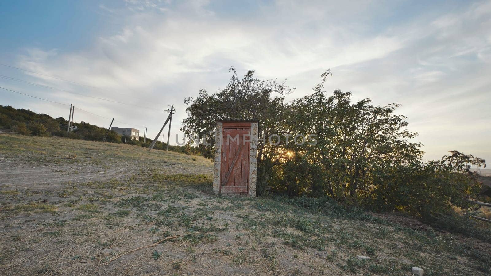 Old wooden toilet standing on a hill in Crimea at sunset near Belogorsk