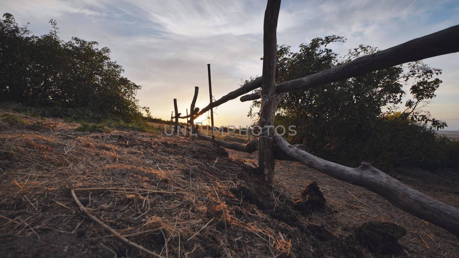 Rustic wooden fence dividing fields in the Crimean countryside at sunset, near the town of Belogorsk