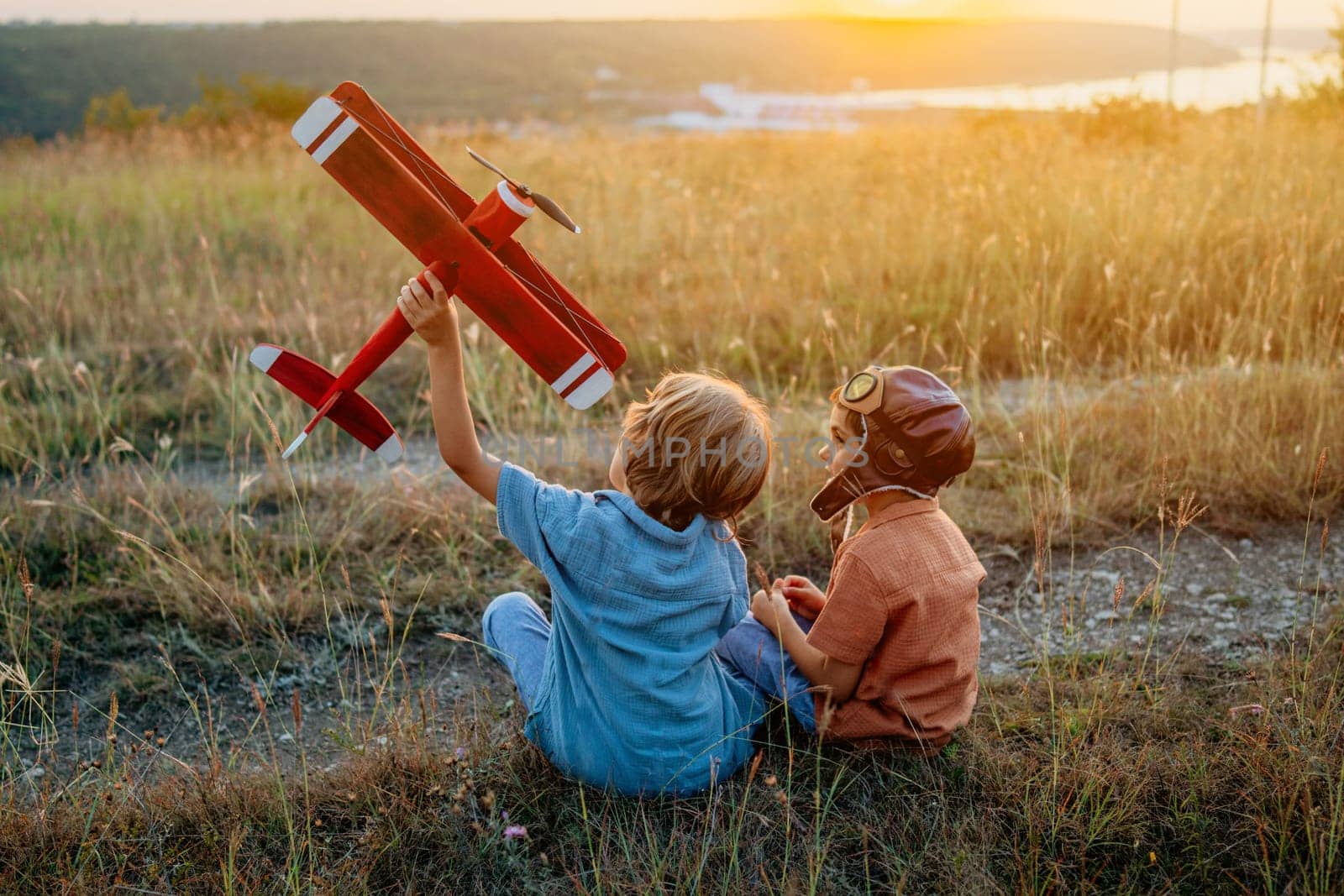 Smiling interested friends brothers, cute boys plays, talks about aviation with handmade wooden vintage plane toy, discovering future pilot profession interests, dreamers kids flying, traveling.