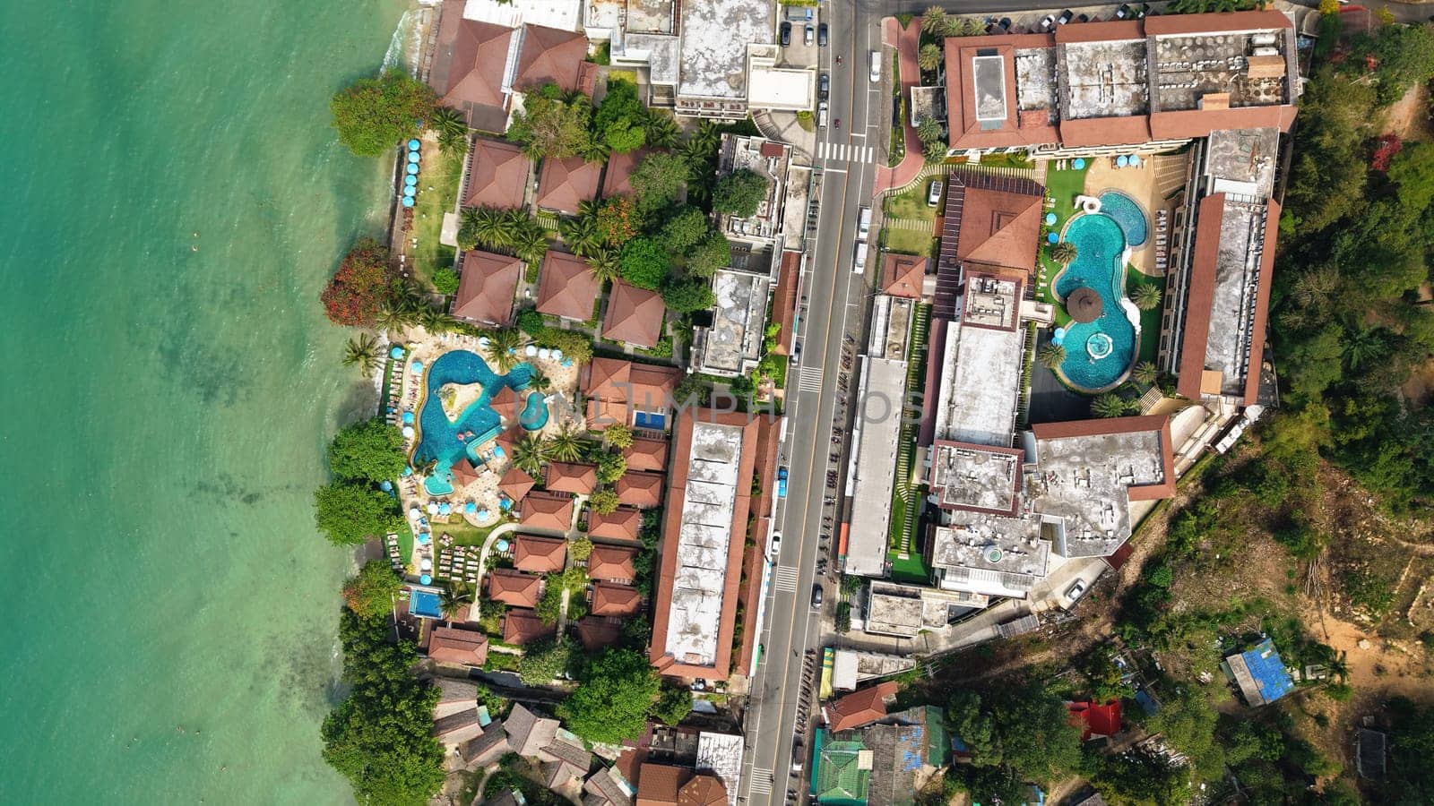Stunning aerial view capturing the layout of a tropical resort and hotel complex with swimming pools. Nestled along a picturesque coastline. Showcasing the vibrant turquoise waters and lush greenery