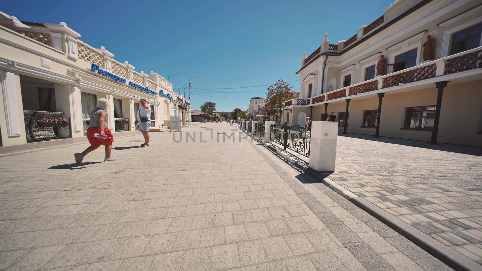 People walking on a paved street in Gurzuf, Crimea, Russia, during summer vacation