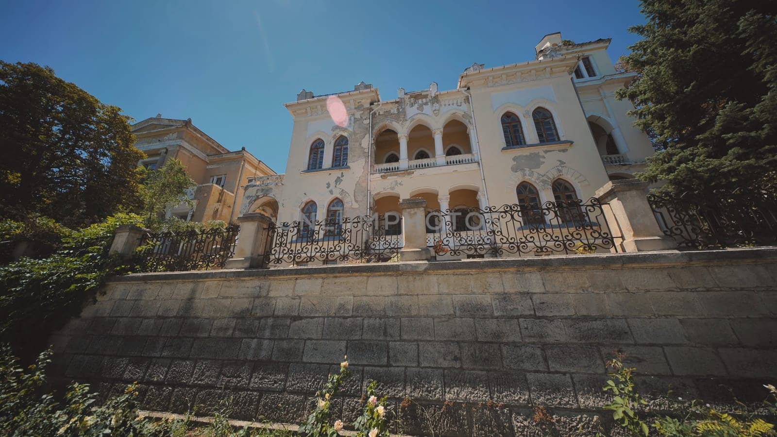 Crumbling facade of a historic mansion in crimea, showcasing its weathered beauty against a backdrop of clear blue skies, overlooking the black sea