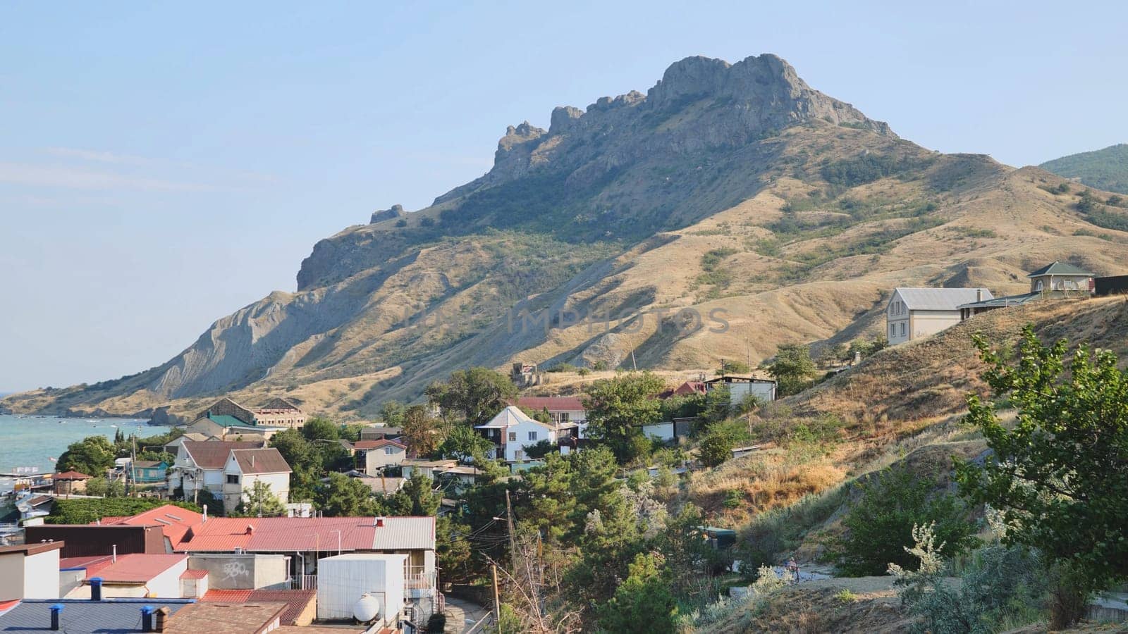 Houses climbing the hills of Koktebel, Crimea, with the extinct volcano Kara Dag dominating the landscape