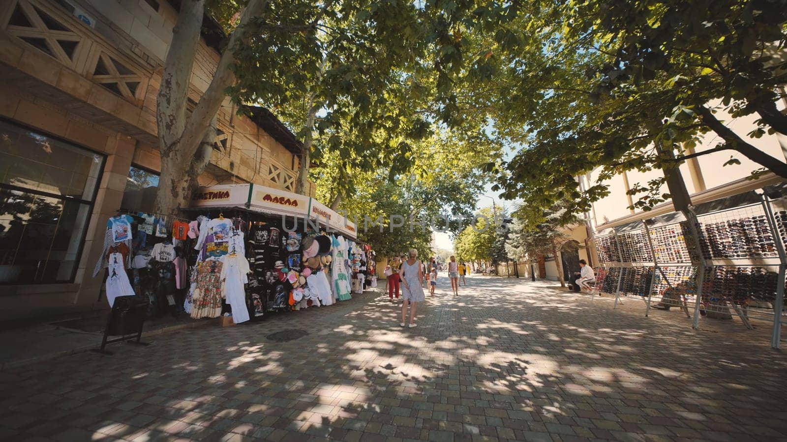 People walking and shopping on a street market in Crimea, Russia, during a sunny summer day