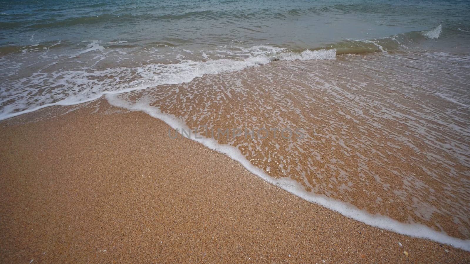 Gentle waves washing golden sand beach on Crimean peninsula, creating relaxing seascape