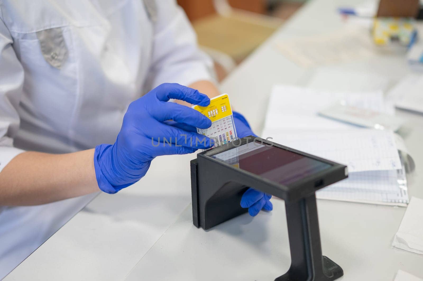 A narcologist tests urine for drugs using an electronic device