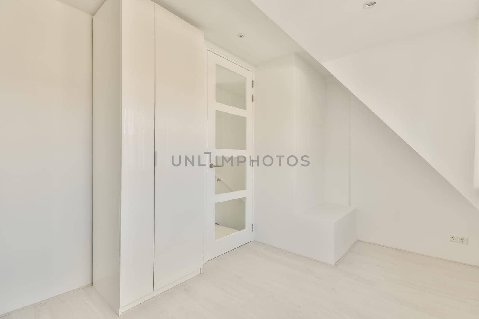 an empty room with white walls and wood flooring, the door is open to reveal a large closet space