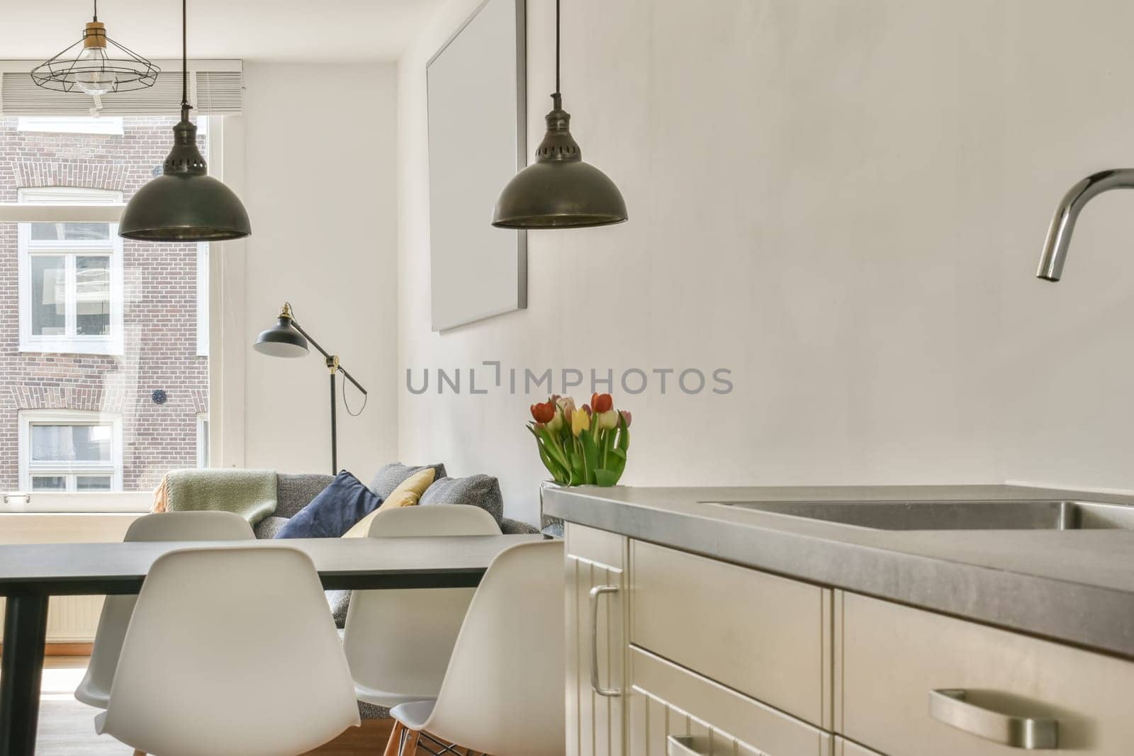 a kitchen and dining area in a modern apartment with white walls, wood flooring and large windows overlooking the city