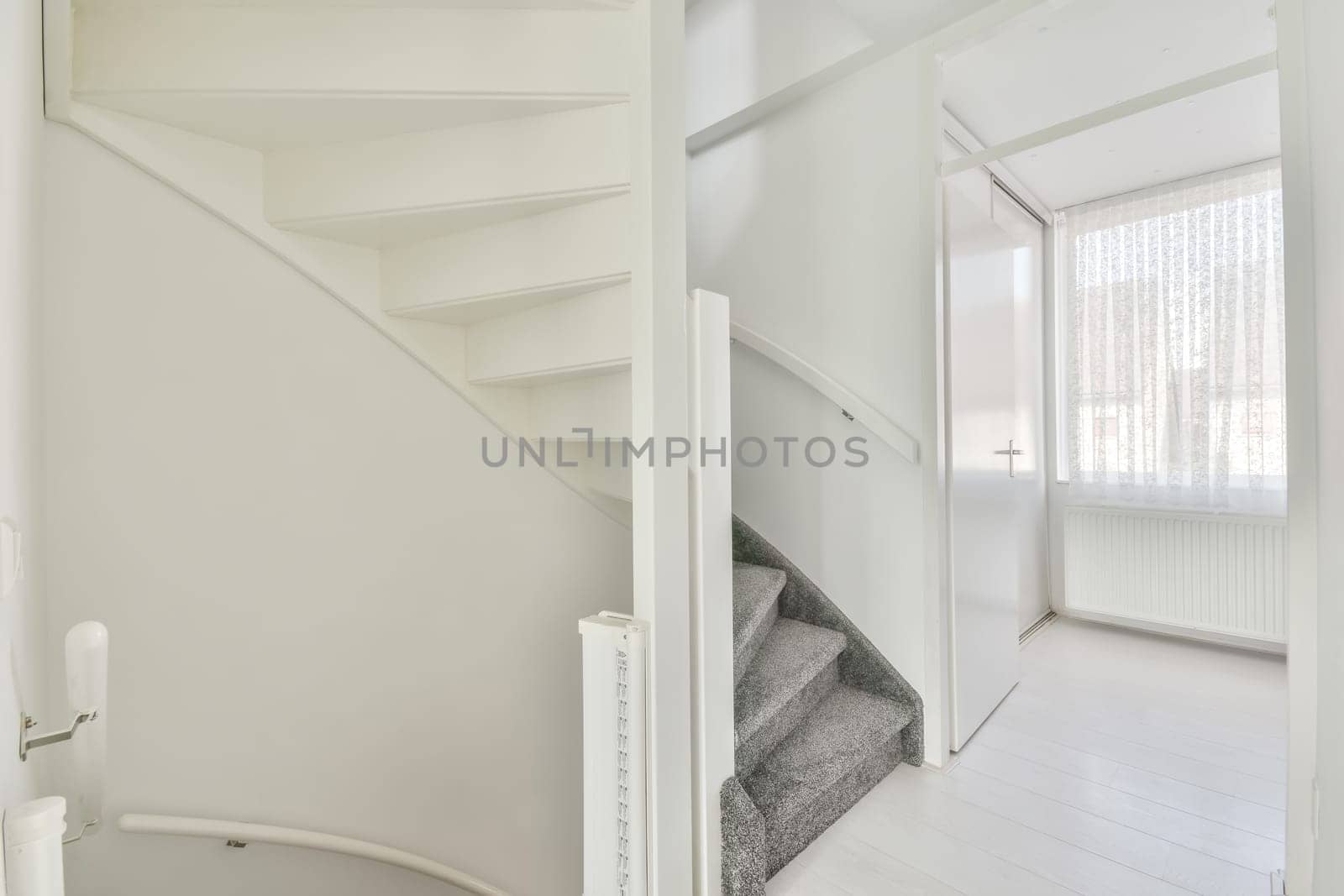 an empty room with white walls and wooden floors, there is a staircase leading to the second floor in this apartment