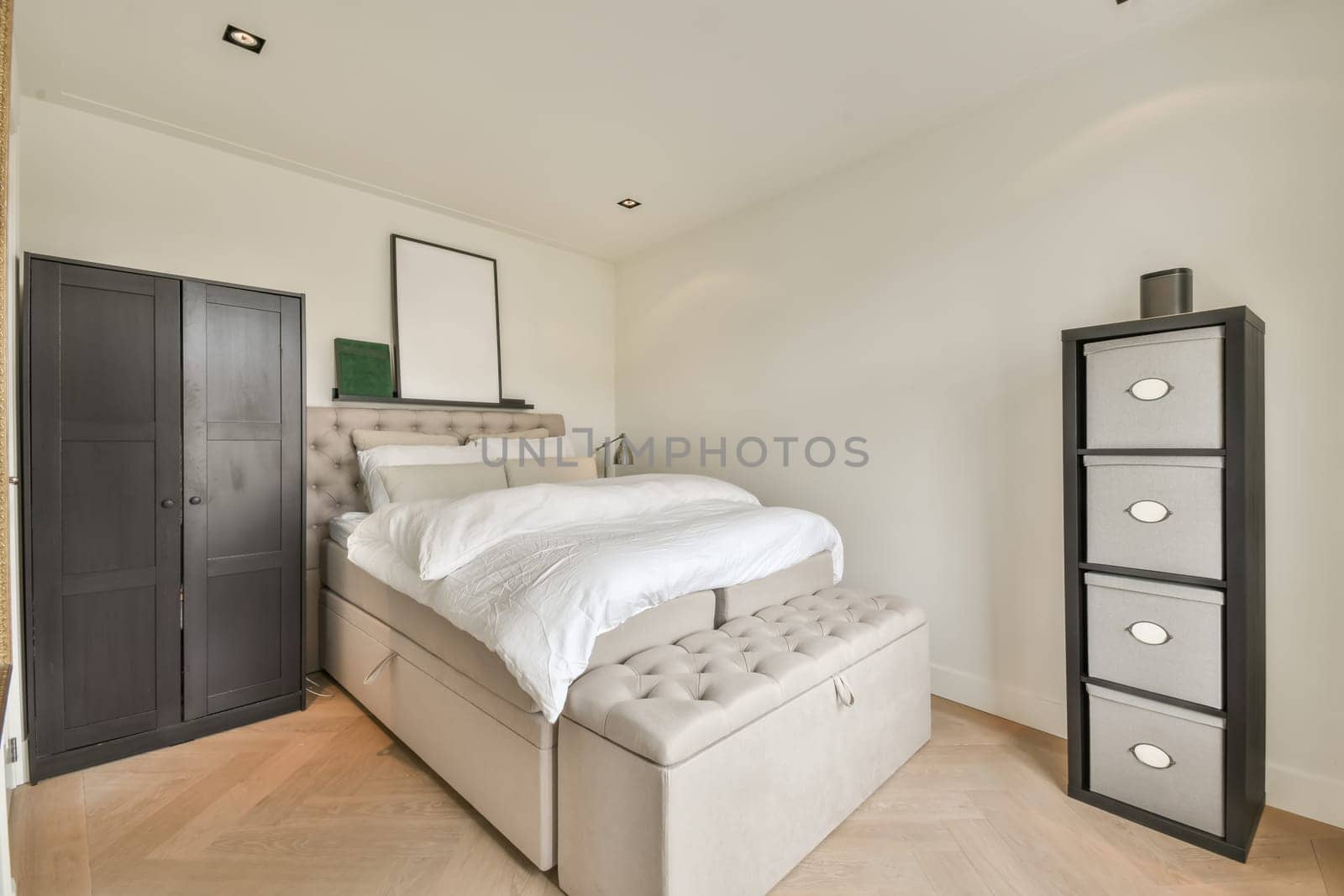 a bedroom with an upholing bed in the middle of the room and storage units on the right side