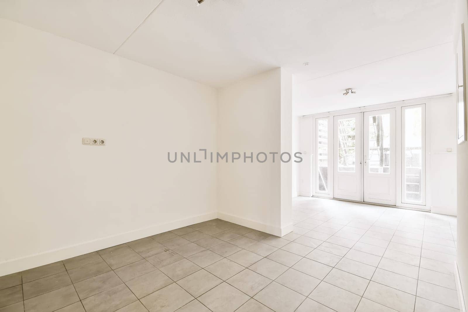 an empty living room with tile flooring and sliding glass door leading to the patio area in this apartment building