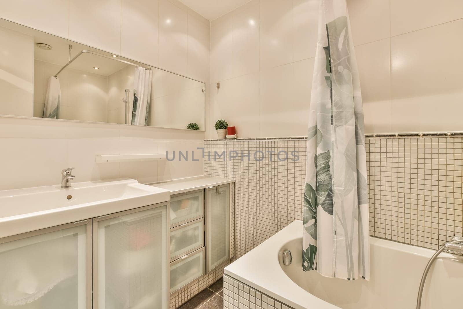 a bathroom with white tiles on the walls, and a large bathtub in the corner next to the sink