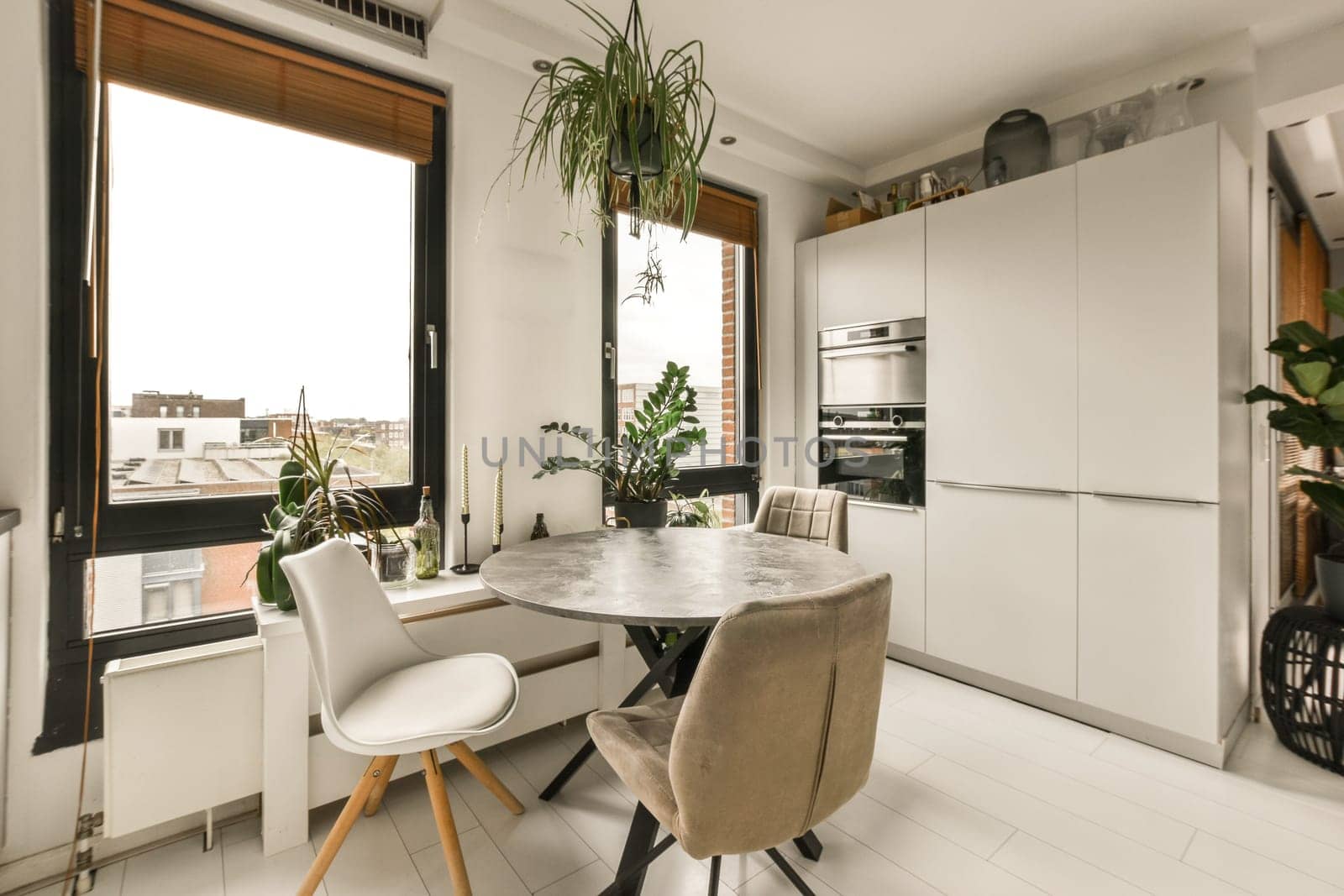 a kitchen and dining area in a house with white tiles on the floor, walls, windows, and doors