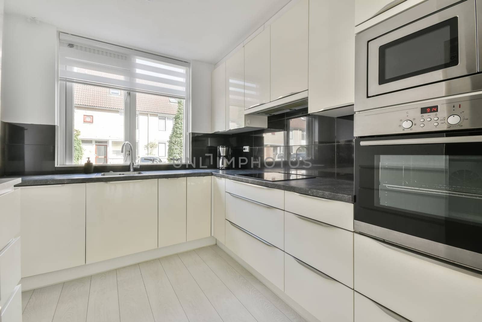 a modern kitchen with white cabinets and black counter tops on the counters in this photo is taken from the inside