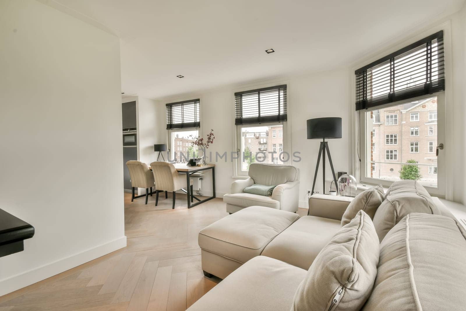 a living room with white walls and wood flooring in the center of the room is a large window that looks out onto the