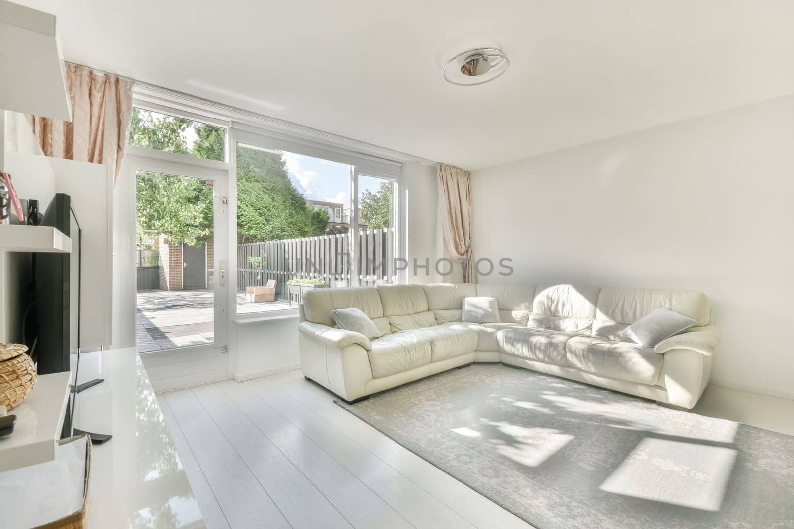 a living room with white couches and a television set in the center of the room is an outdoor patio