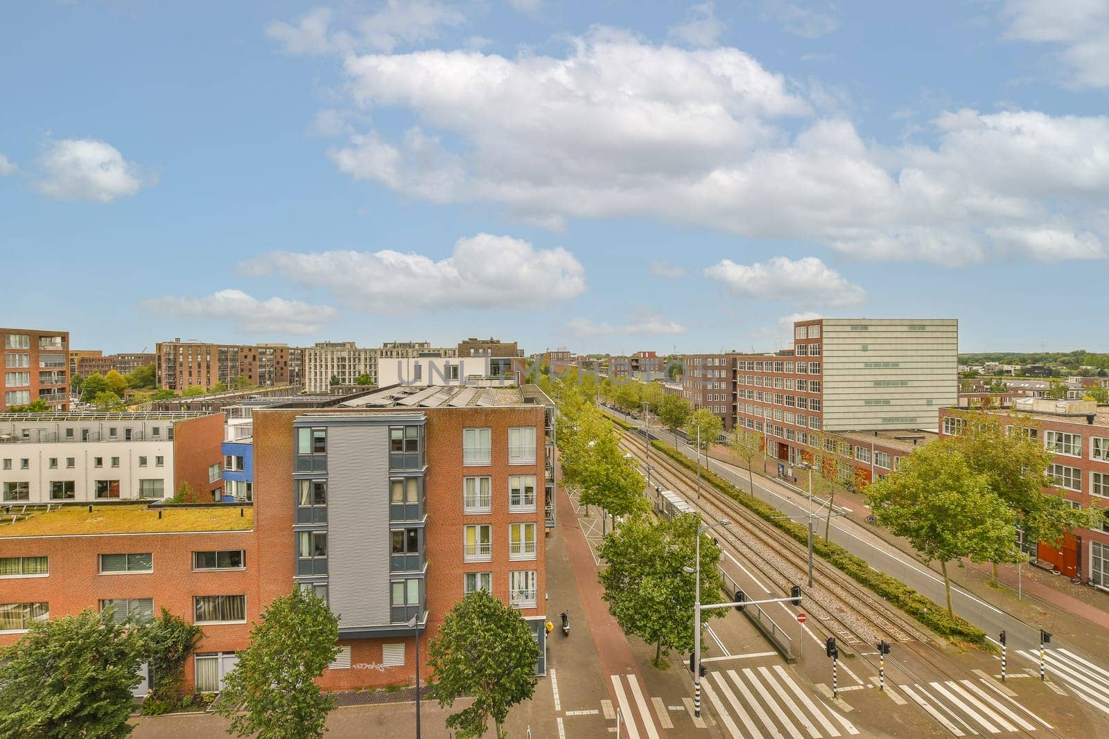 a city with buildings and train tracks in the middle part of the photo is taken from an overpass bridge